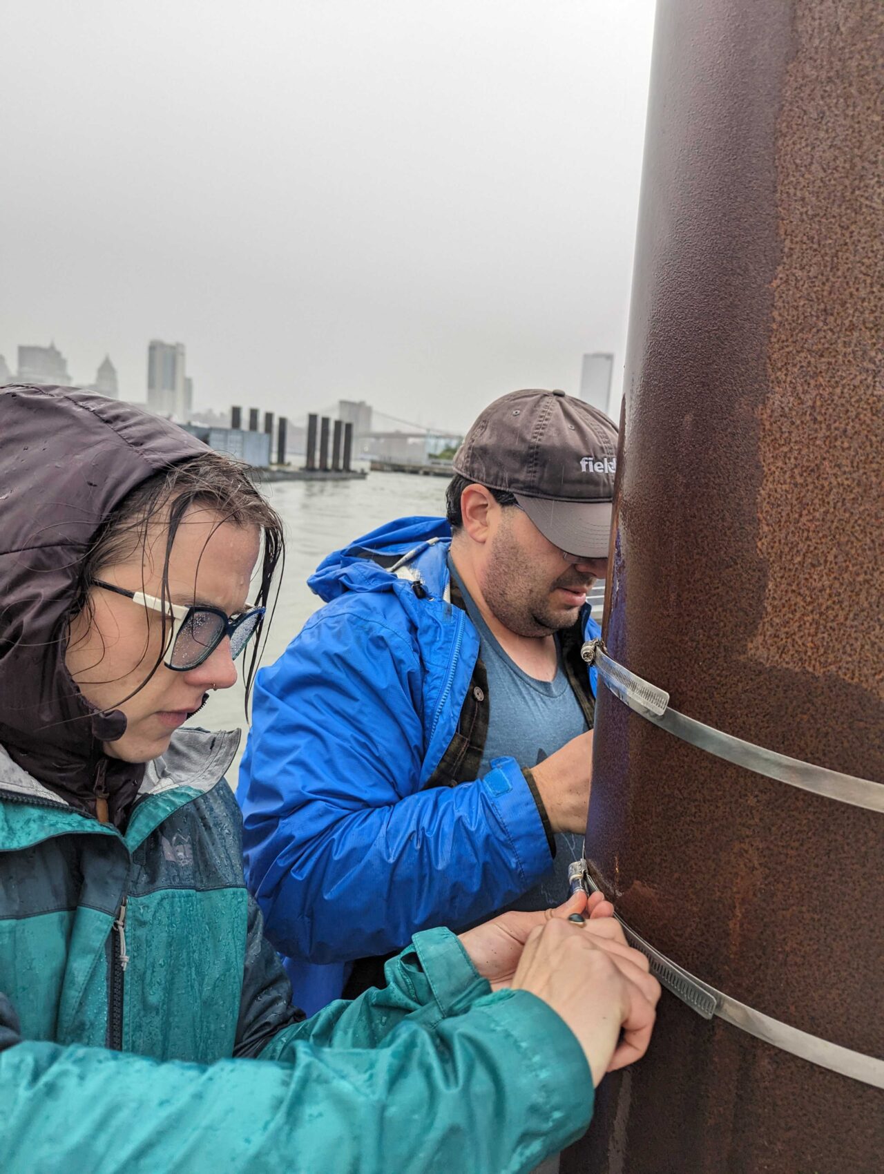 Pete and Lindsay work to install the strut holding the distance sensor in the rain